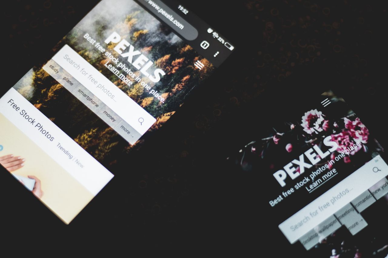 मुखपृष्ठ Close-up of smartphones displaying Pexels stock photo website, showcasing modern technology.